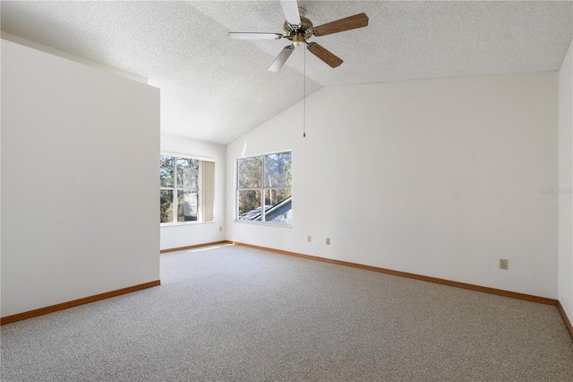 unfurnished room with lofted ceiling, carpet flooring, a textured ceiling, and ceiling fan