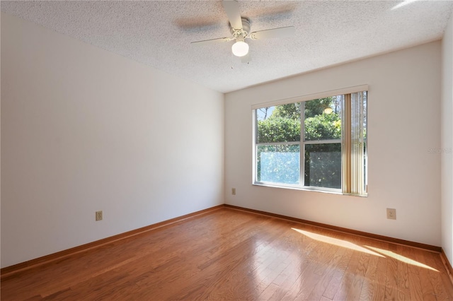 empty room with ceiling fan, hardwood / wood-style floors, and a textured ceiling