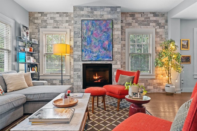 living area featuring a large fireplace and wood-type flooring