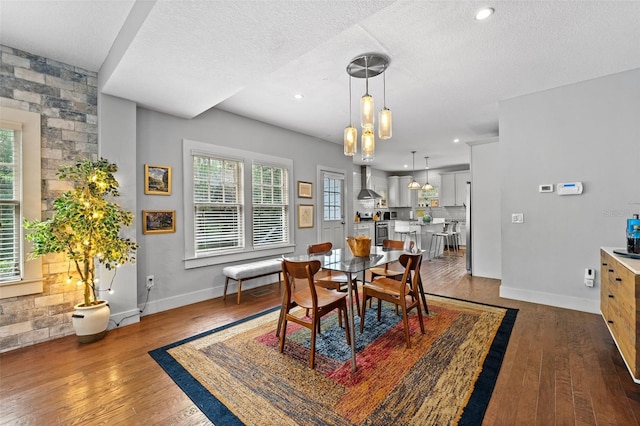 dining space featuring dark hardwood / wood-style flooring and a textured ceiling