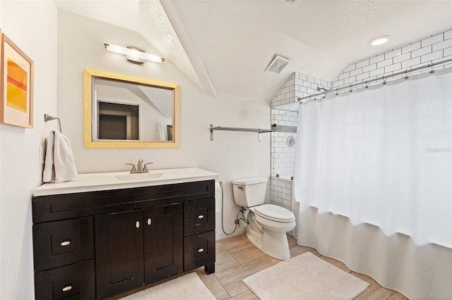 full bathroom featuring shower / tub combo, vanity, a textured ceiling, vaulted ceiling, and toilet