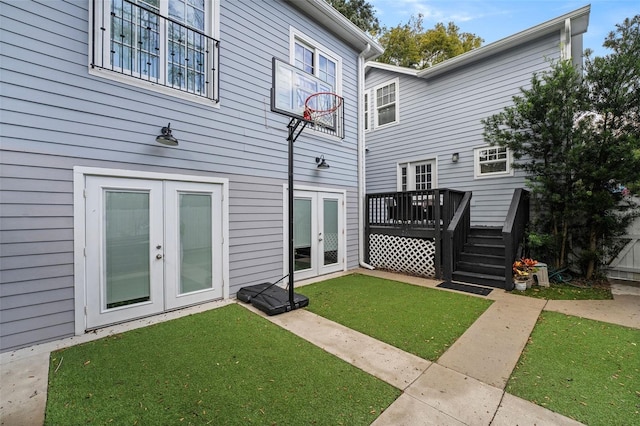 exterior space with french doors, a deck, and a lawn