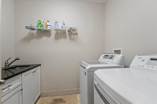 washroom featuring cabinets, sink, and washer and clothes dryer