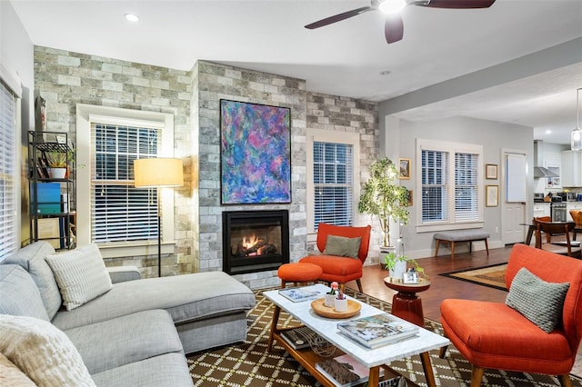 living room featuring hardwood / wood-style flooring, a fireplace, and ceiling fan