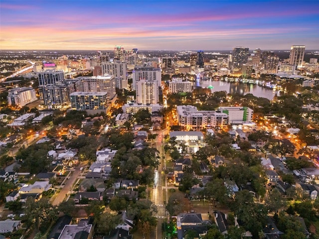 aerial view at dusk featuring a water view