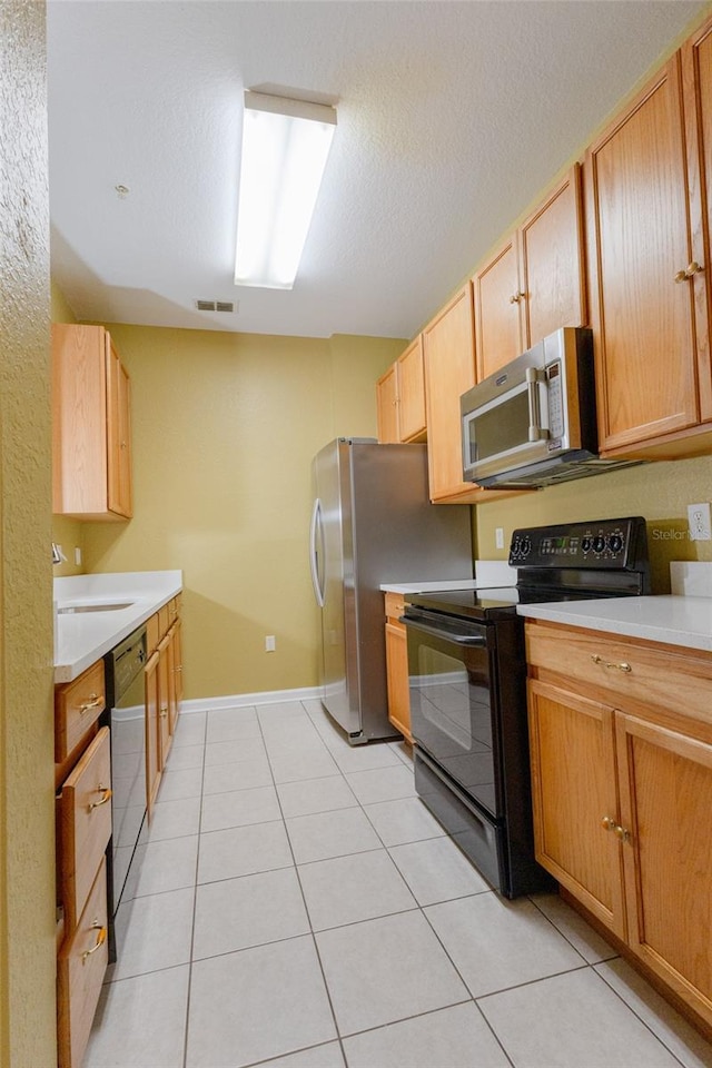 kitchen featuring light tile patterned flooring, sink, a textured ceiling, and black appliances