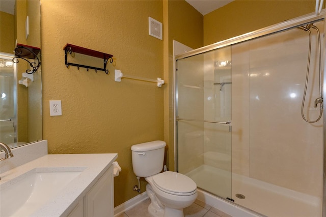 bathroom with vanity, tile patterned floors, a shower with door, and toilet