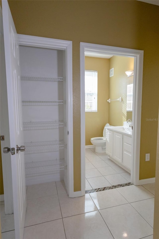 bathroom featuring vanity, toilet, and tile patterned flooring