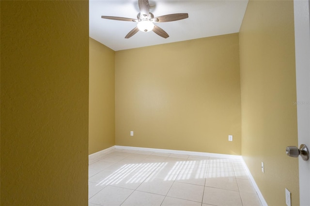 tiled empty room featuring ceiling fan