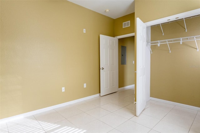 unfurnished bedroom featuring light tile patterned floors, electric panel, and a closet