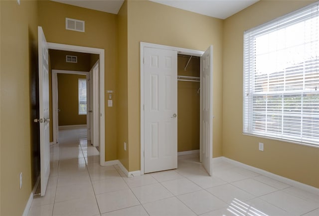 unfurnished bedroom featuring light tile patterned flooring and a closet