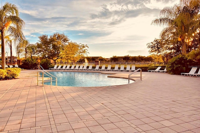 pool at dusk with a patio