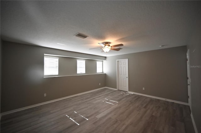 unfurnished room featuring ceiling fan, dark hardwood / wood-style flooring, and a textured ceiling