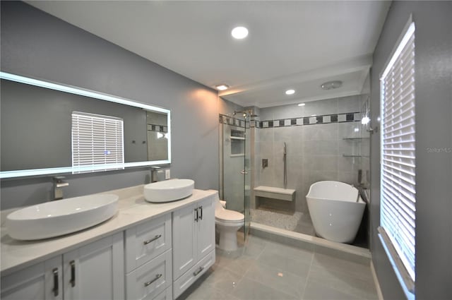 full bathroom with shower with separate bathtub, vanity, tile patterned floors, and toilet