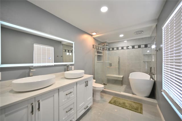 full bathroom with tile patterned flooring, shower with separate bathtub, vanity, and toilet