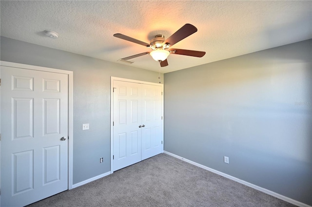 unfurnished bedroom featuring ceiling fan, carpet, a textured ceiling, and a closet