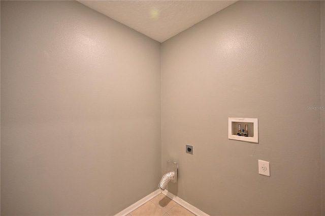 washroom with washer hookup, hookup for an electric dryer, a textured ceiling, and light tile patterned floors