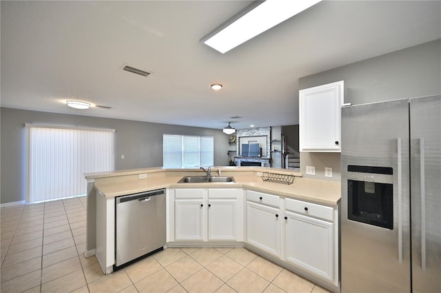 kitchen with white cabinetry, sink, stainless steel appliances, and kitchen peninsula