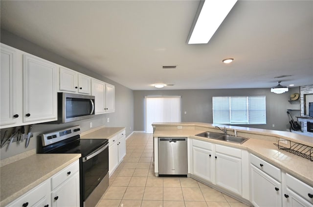 kitchen featuring stainless steel appliances, white cabinetry, sink, and light tile patterned floors