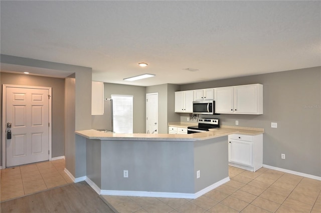 kitchen with white cabinetry, appliances with stainless steel finishes, kitchen peninsula, and light tile patterned floors