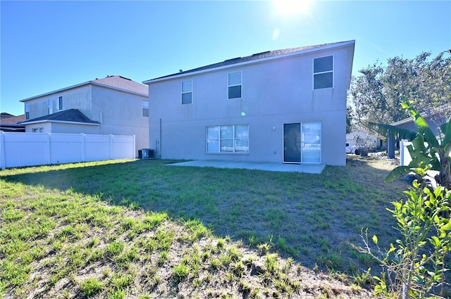 back of house with central AC unit, a patio area, and a lawn