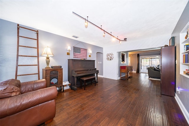 living room with dark hardwood / wood-style floors and track lighting