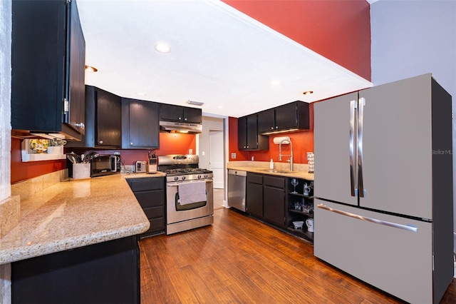 kitchen featuring light stone counters, stainless steel appliances, dark hardwood / wood-style flooring, and sink