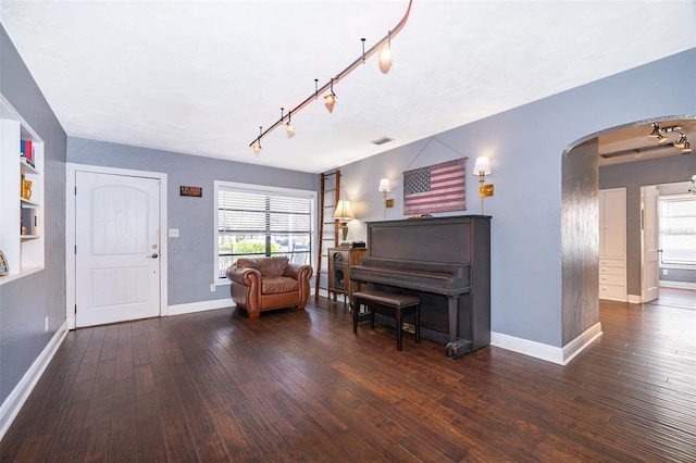 interior space featuring rail lighting and dark wood-type flooring