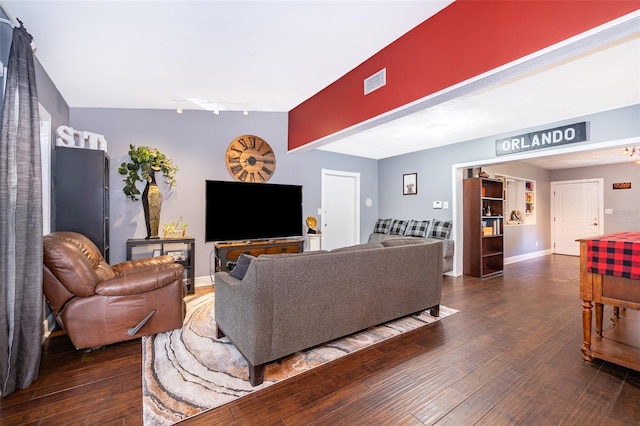 living room with beam ceiling, dark wood-type flooring, and track lighting