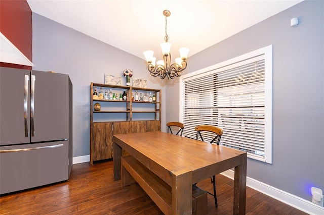 dining area with an inviting chandelier, lofted ceiling, and dark hardwood / wood-style flooring