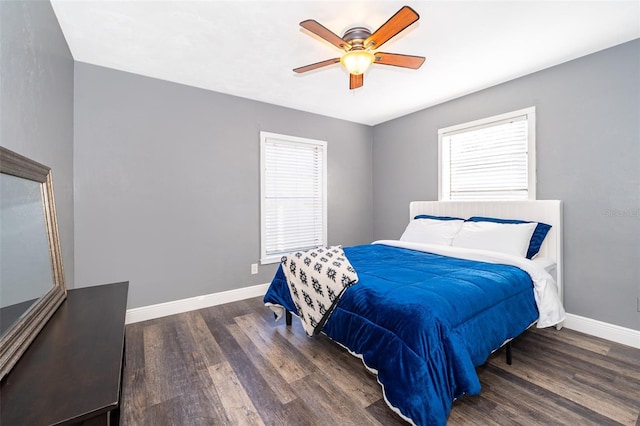 bedroom with ceiling fan, dark hardwood / wood-style flooring, and multiple windows