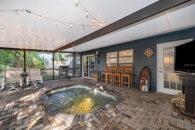 view of swimming pool with a bar, area for grilling, a hot tub, and a patio area