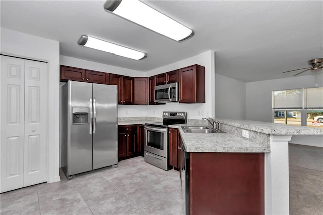 kitchen with sink, a breakfast bar area, stainless steel appliances, light tile patterned flooring, and kitchen peninsula