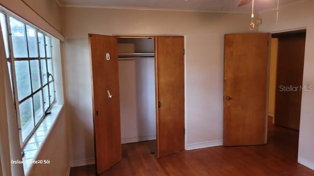 unfurnished bedroom with dark wood-type flooring and a closet