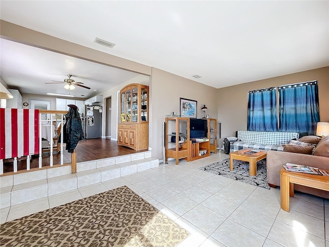 tiled living room with ceiling fan