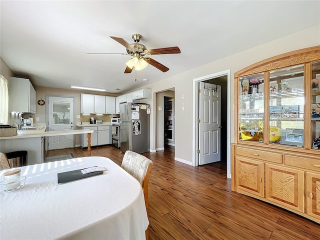 dining room with sink, dark hardwood / wood-style floors, and ceiling fan