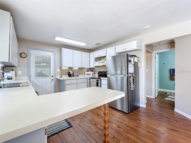 kitchen with sink, appliances with stainless steel finishes, kitchen peninsula, white cabinets, and backsplash