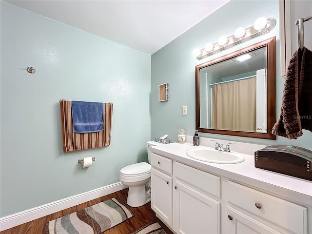 bathroom featuring wood-type flooring, vanity, and toilet