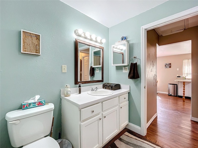 bathroom featuring vanity, wood-type flooring, and toilet