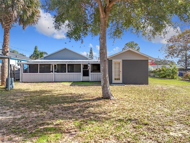 back of property featuring a sunroom and a yard