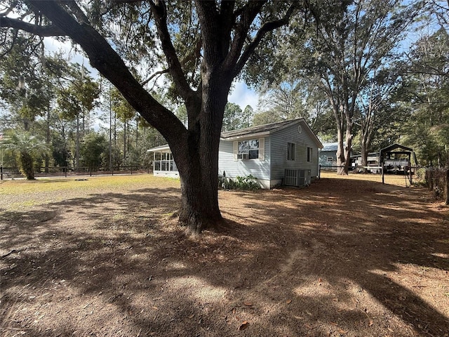 view of yard featuring a sunroom and central air condition unit