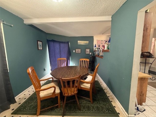 dining room featuring beam ceiling, light tile patterned floors, and a textured ceiling