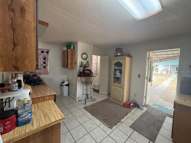 kitchen featuring sink, light tile patterned floors, and a textured ceiling