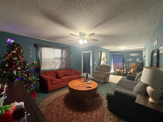 living room featuring carpet floors, a textured ceiling, and ceiling fan