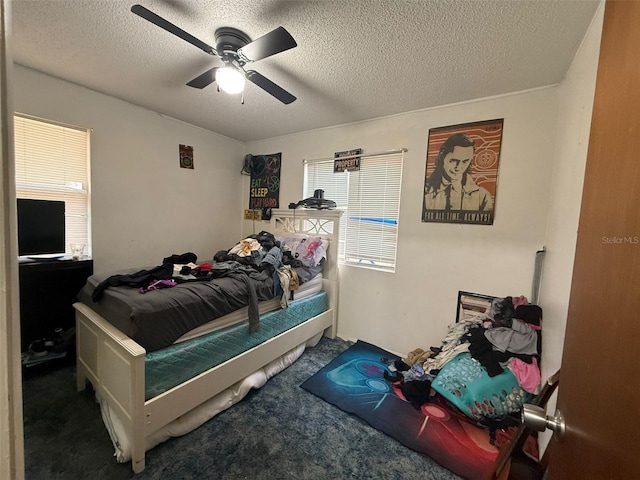 carpeted bedroom with a textured ceiling and ceiling fan