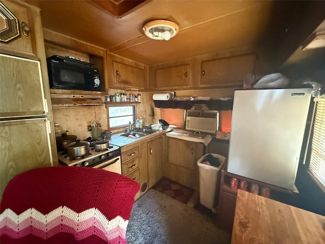 kitchen with paneled refrigerator, sink, and gas range gas stove