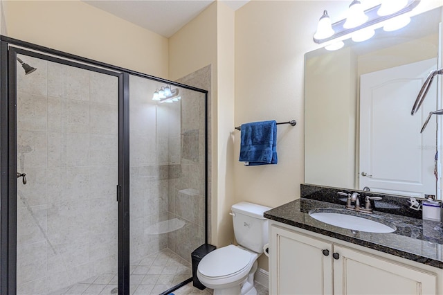 bathroom with vanity, a shower with shower door, and toilet