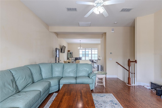 living room featuring dark hardwood / wood-style flooring and ceiling fan with notable chandelier