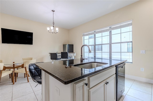 kitchen with sink, decorative light fixtures, a center island with sink, light tile patterned floors, and white cabinets