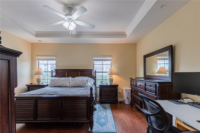 bedroom with dark wood-type flooring, ceiling fan, a raised ceiling, and multiple windows